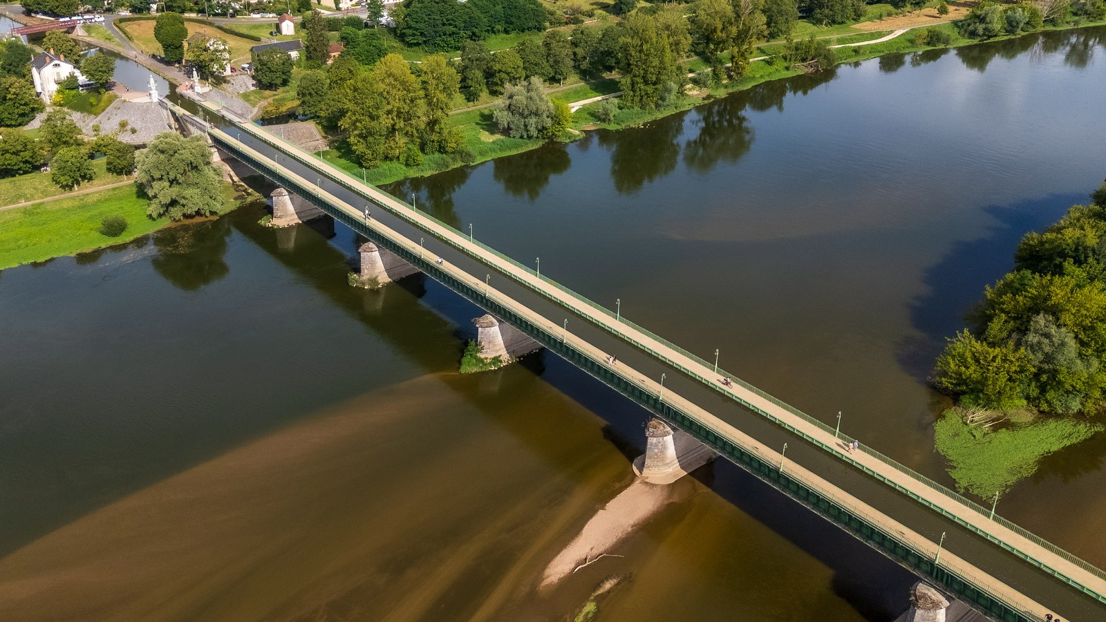 Vue aérienne du pont-canal de Briare, bande d'eau bordée de garde-corps verts, posée sur des piles en pierre au-dessus de la Loire