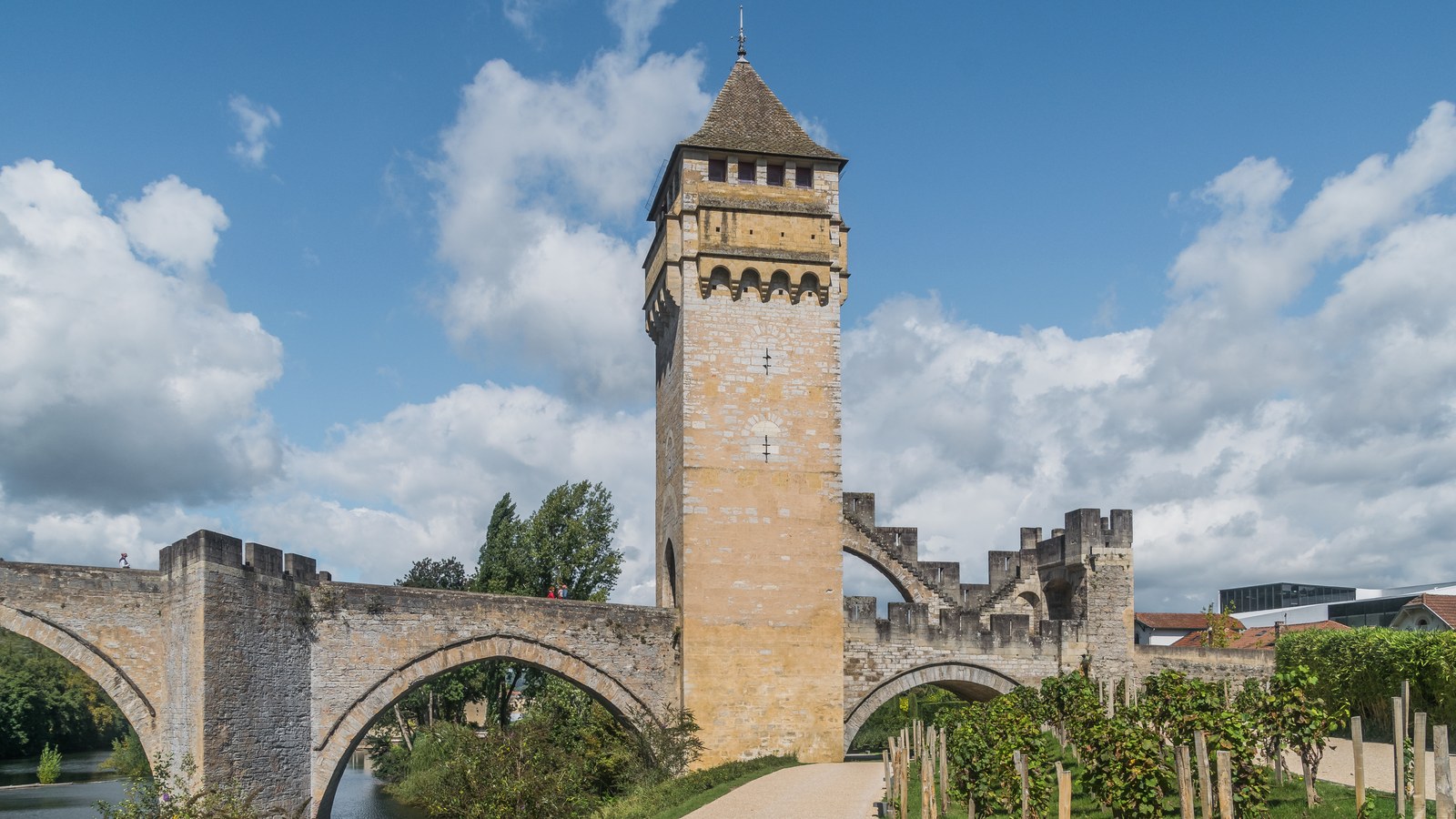 Une tour carrée du pont Valentré à Cahors, avec ses machicoulis et son toit de lauzes, au-dessus d'une arche du pont