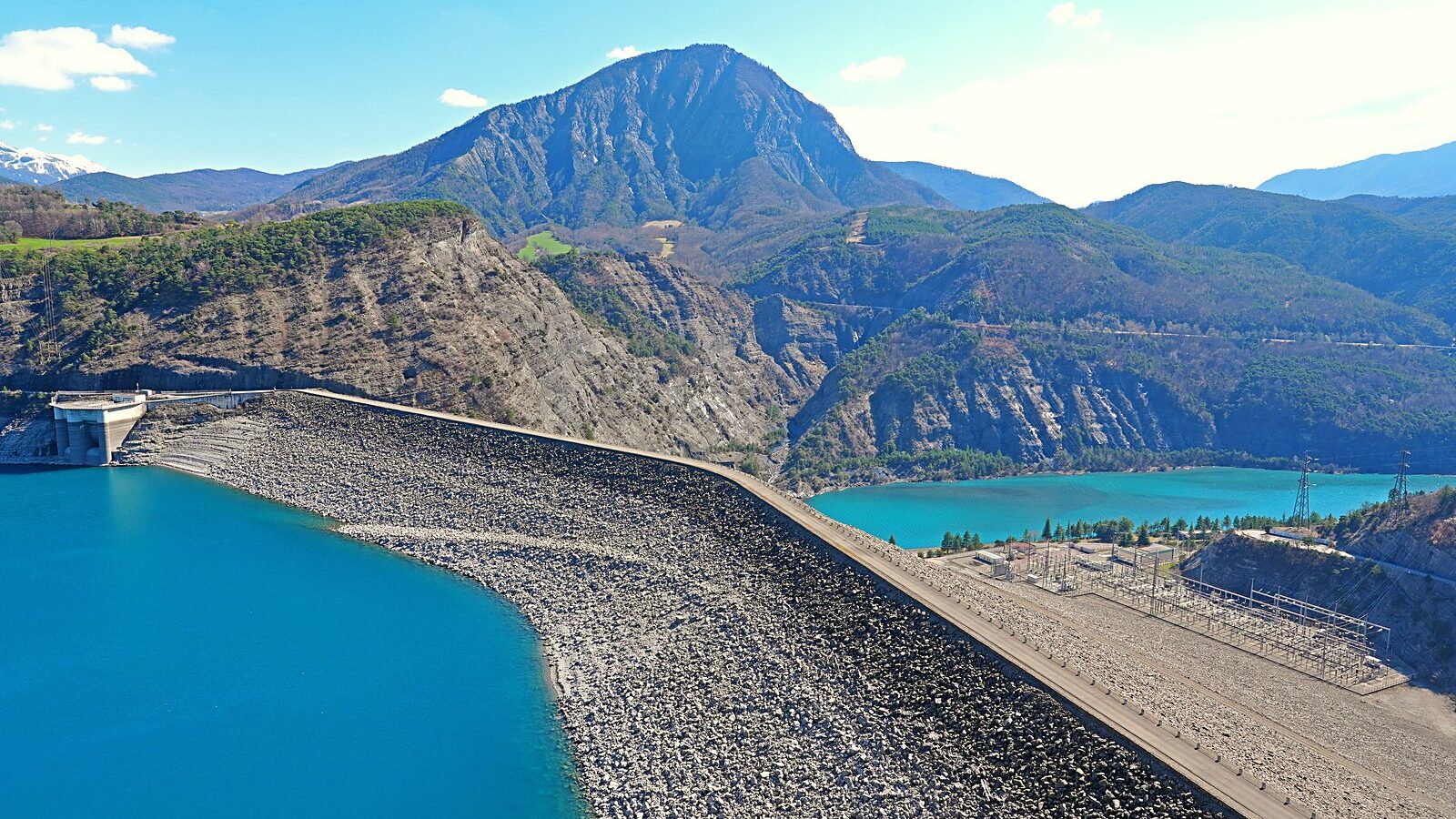 La crête du barrage de Serre-Ponçon et son parement d'enrochements, au-dessus du lac turquoise