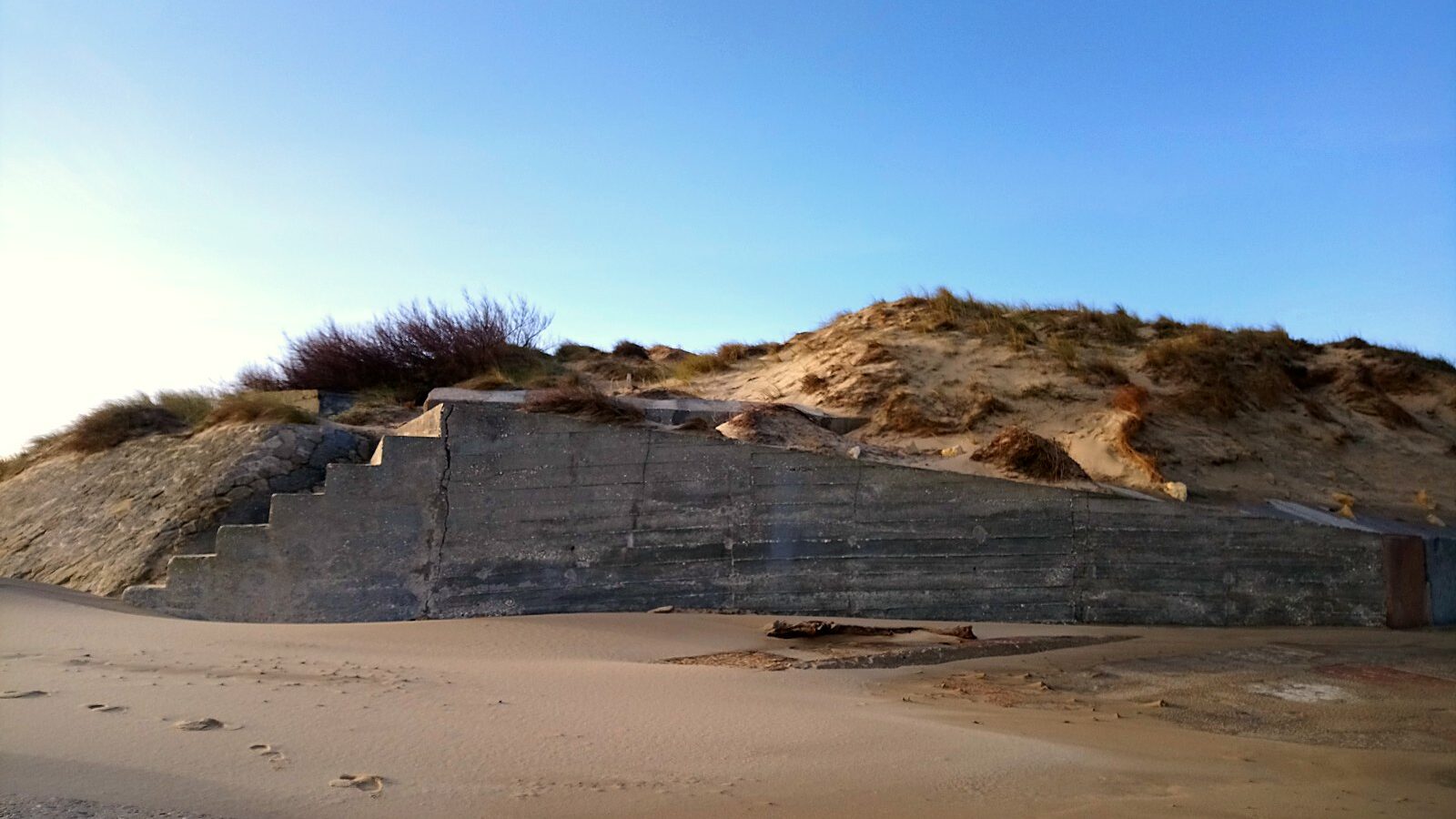 Un ouvrage bétonné à demi enfoui dans la dune, au Verdon-sur-Mer, en Gironde