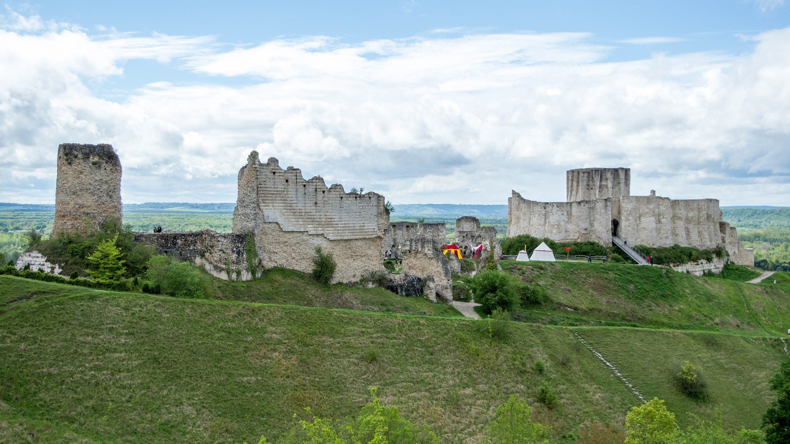 Les ruines de Château-Gaillard sur leur colline verte, avec une haute tour à gauche et le donjon entouré de sa chemise à droite