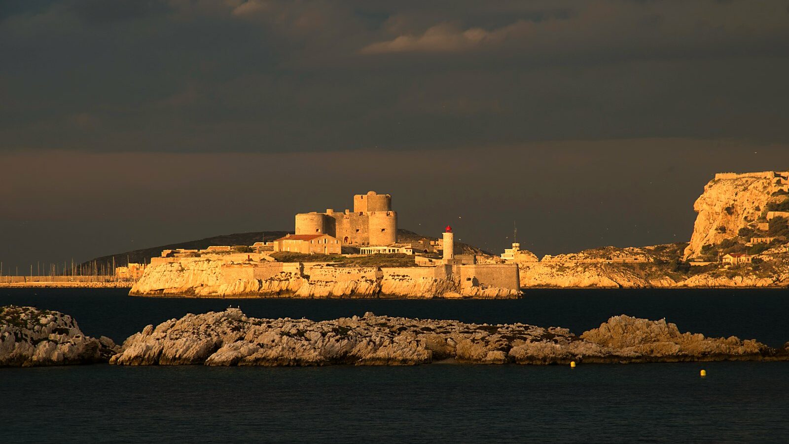 Le château d'If et son île, vus depuis la mer, avec l'archipel du Frioul en arrière-plan
