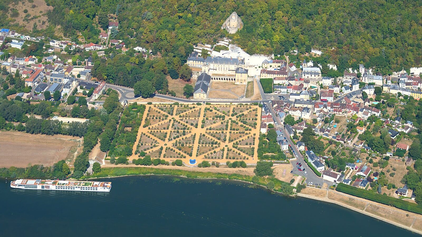 Vue aérienne de La Roche-Guyon, son donjon sur le coteau, le château et le potager au bord de la Seine