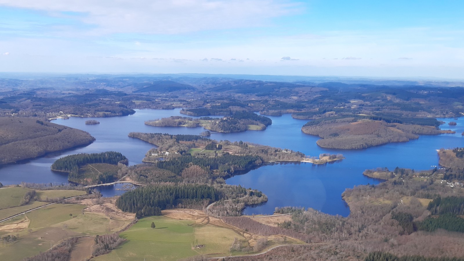 Vue aérienne du lac de Vassivière, ses presqu'îles boisées et ses îles au milieu des collines du Limousin