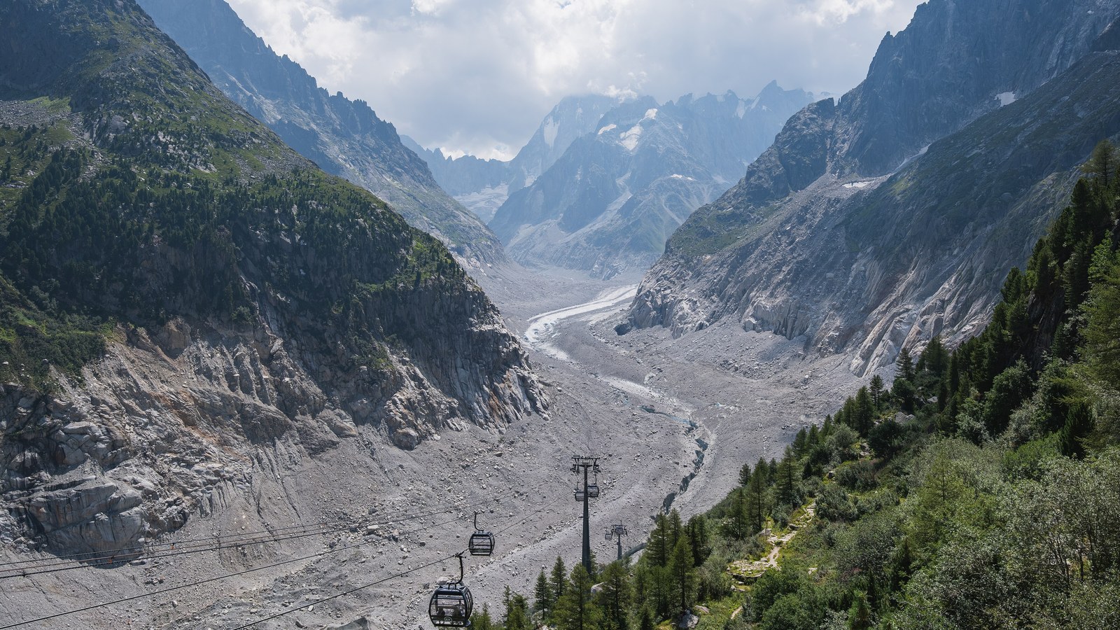 La mer de Glace couverte de moraine vue depuis le Montenvers, avec les cabines de la nouvelle télécabine au premier plan