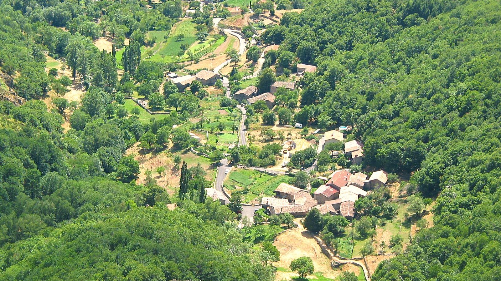 Un hameau de Montpezat-sous-Bauzon et sa route en lacets, vus d'un versant