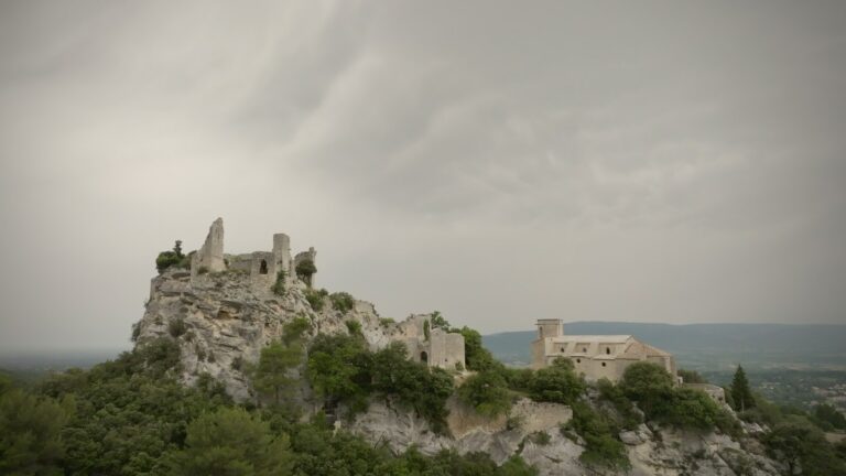 Ruines du château d'Oppède-le-Vieux sur son rocher, à côté de l'église, sous un ciel gris