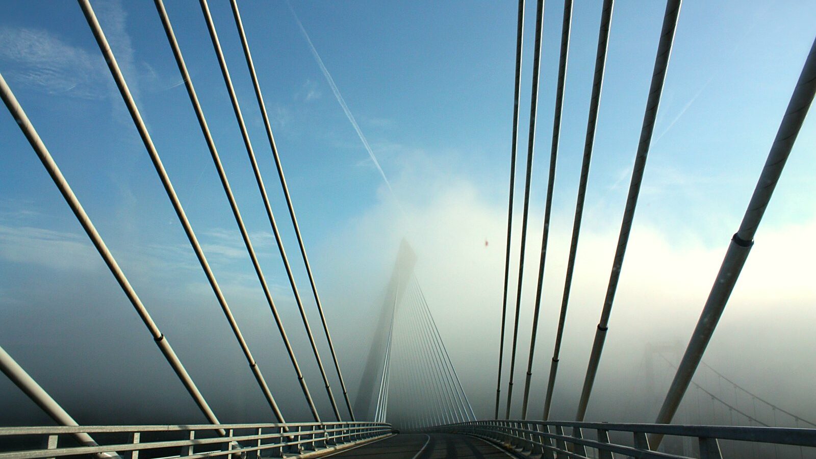 Le tablier du pont de Térénez, ses haubans et son pylône dans la brume, dans le Finistère
