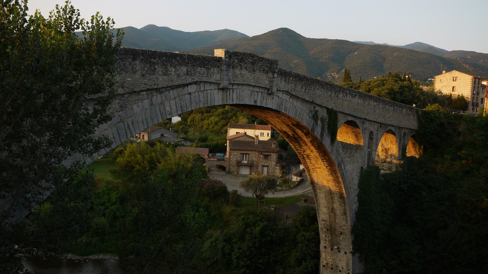 Le vieux pont de Céret, dit pont du Diable, et sa grande arche unique, avec les montagnes du Vallespir en arrière-plan