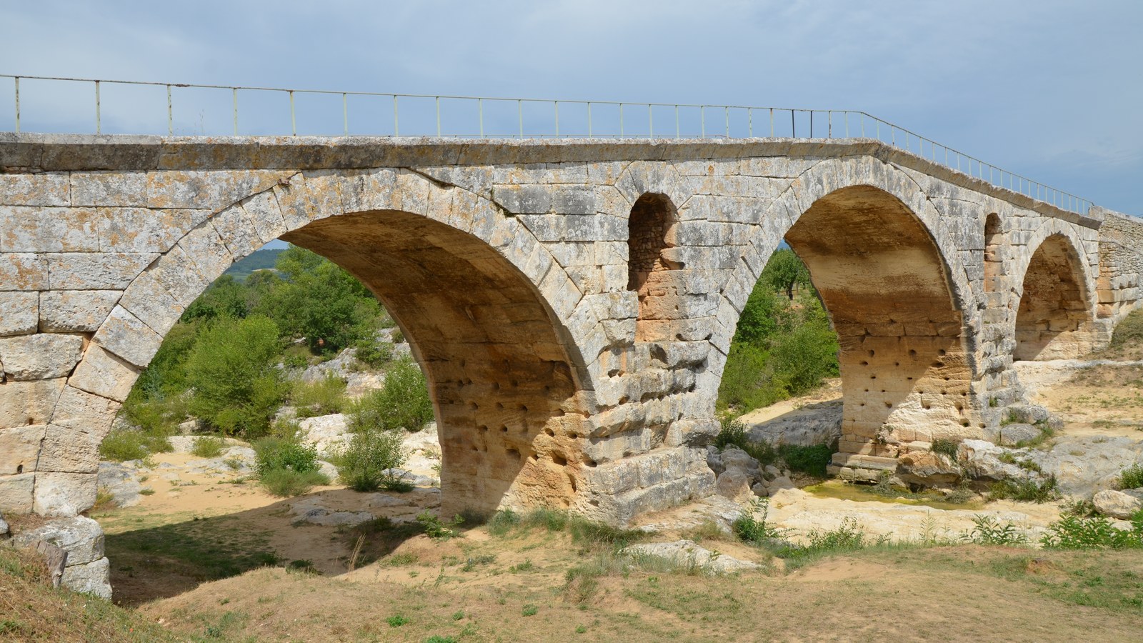 Le pont Julien et ses arches en plein cintre, avec une ouverture au-dessus de chaque pile, sur le lit du Calavon