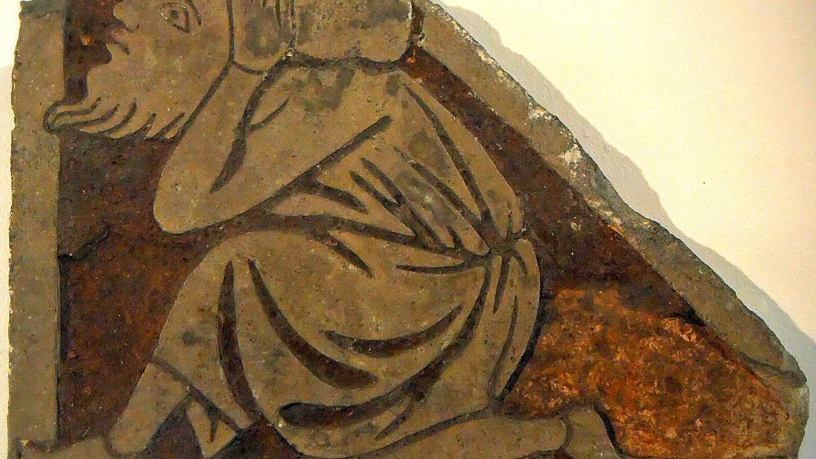 Un carreau de pavement orné d'un homme genou à terre, provenant des fouilles de la cathédrale de Thérouanne