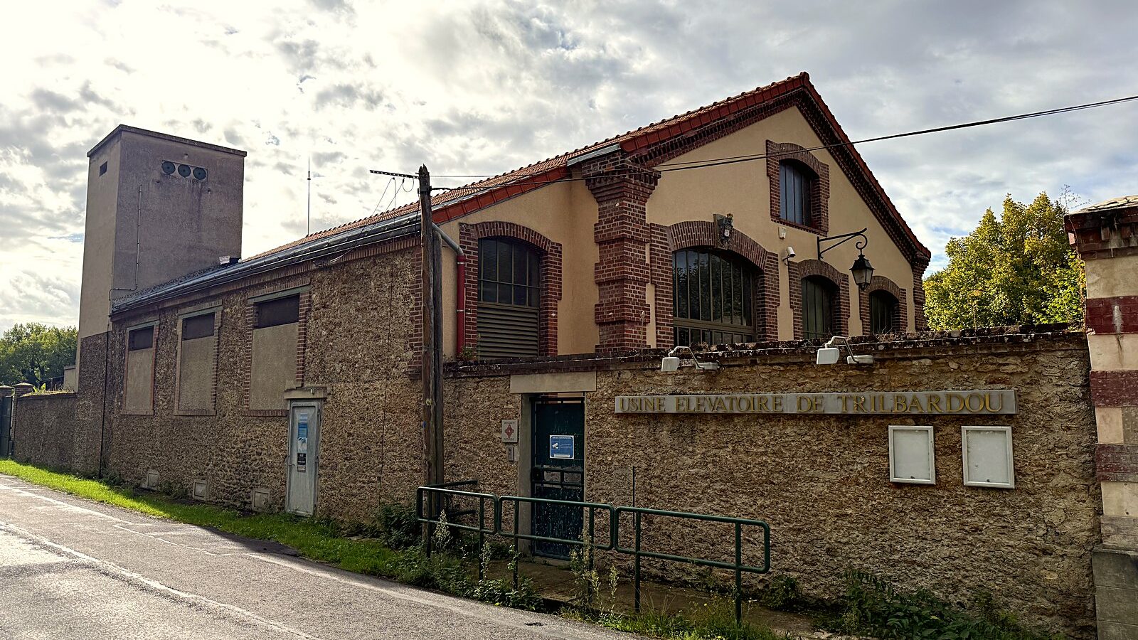 Les halles de l'usine élévatoire de Trilbardou et sa tour, le long de la route